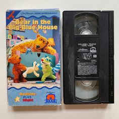 an old vhs tape recorder sitting next to a bear in the big blue house dvd