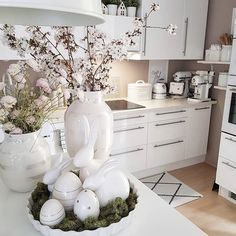 a kitchen with white cabinets and countertops has an arrangement of eggs in a bowl