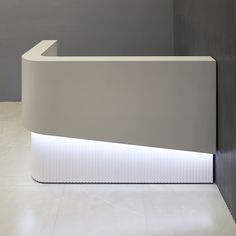 a white counter sitting next to a gray wall in a room with tile flooring