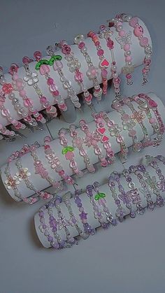 several rolls of pink and white bracelets with teddy bears on them sitting next to each other