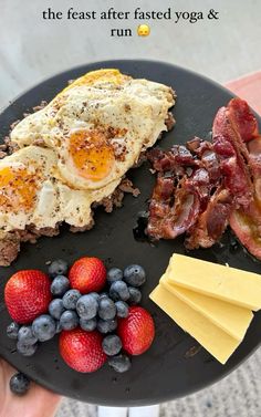 a plate with eggs, bacon, strawberries and cheese