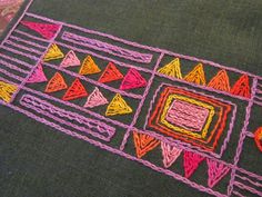 a close up of a piece of cloth with different colored stitchs on the fabric