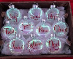 twelve christmas baubles in a box with the words joy, hope, faith, peace, and jesus written on them