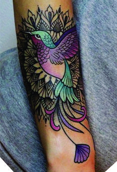 a woman's arm with a tattoo on it and a humming bird in the middle