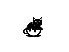 a black cat sitting on top of a cup