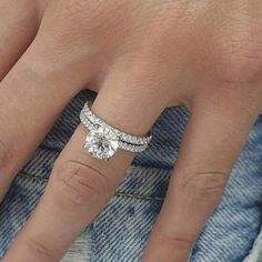 a close up of a person's hand with a diamond ring on their finger