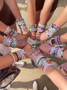 a group of people standing in a circle holding their hands together with numbers on them