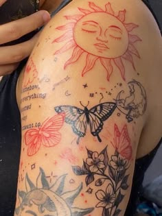 a woman's arm with tattoos on it and flowers, butterflies, and sun