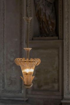 a chandelier hanging from the ceiling in a room with marble walls and flooring