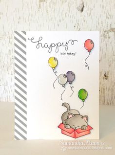 a birthday card with balloons and a cat in a box on top of the card