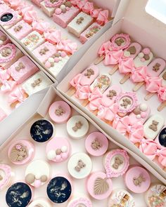 two boxes filled with pink and white cupcakes