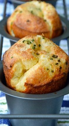 three muffins sitting in a metal pan on a blue and white table cloth