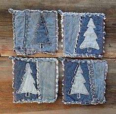 four pieces of denim with christmas trees on them sitting on top of a wooden table