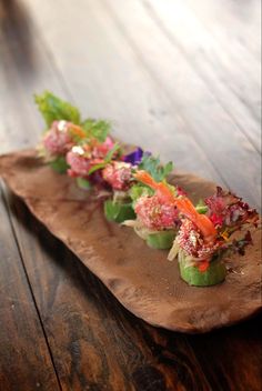 a wooden platter filled with different types of appetizers on top of it