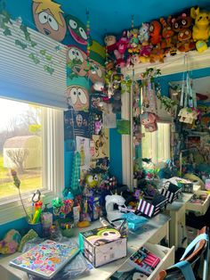 a room filled with lots of stuffed animals and other things hanging from the ceiling next to a window