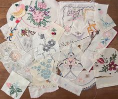 a pile of embroidered handkerchiefs sitting on top of a wooden floor