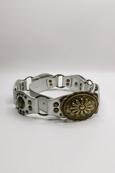 The Bianca Studded Floral Buckle Belt brings a bold statement to your style. Made from premium faux-leather, this belt is available in silver, black, or brown, offering options for any look. Featuring antiqued gold links and stud details, it adds an edge to your ensemble while maintaining a chic, feminine vibe. The standout feature is the floral detailed buckle, which adds a touch of charm to the belt’s bold design. Perfect for pairing with jeans or dresses, the Bianca belt effortlessly blends e Trendy Silver Belt Buckle With Belt Included, Chic Adjustable Belt With Antique Buckle, Chic Adjustable Belts With Antique Buckle, Vintage Adjustable Metal Belt, Adjustable Silver Belt With Buckle Closure, Chic Adjustable Belts For Festivals, Elegant Leather Festival Belts, Elegant Leather Belt For Festival, Elegant Leather Belts For Festival