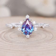 a blue and white ring sitting on top of a piece of wood with diamonds around it