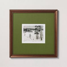 a black and white photo hanging on the wall next to a green framed artwork piece