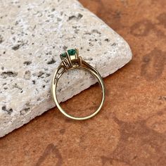 Estate/ vintage polished 10KT yellow gold ring with center, lab-created emerald + surrounding white diamonds. Timeless gold ring with a beautiful, vibrant green emerald! Size 7.25 Can be resized for an additional fee Weight: 1.8g (2) 1 pt genuine, white diamonds; SI clarity; H color Approx. 6mm x 4mm lab-created, green, rectangle center emerald Excellent estate condition Elegant 14k Stamped Emerald Ring, 14k Gold Green Diamond Princess Cut Ring, Princess Cut Green Diamond Ring In 14k Gold, Green Princess Cut Diamond Ring In 14k Gold, Heirloom Emerald Cut Birthstone Ring With Prong Setting, Heirloom Birthstone Ring With Emerald Cut, Yellow Gold Emerald Cluster Ring With Center Stone, Anniversary Emerald Cluster Ring With Birthstone, Timeless Emerald Cut May Birthstone Rings