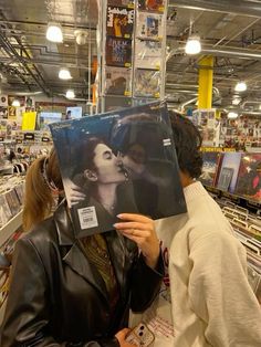 a woman holding up a record in front of her face with an image of two women kissing