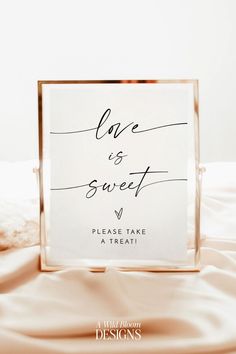 a sign that says love is sweet and please take a treat on top of a bed