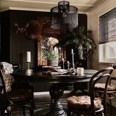 the dining room table is surrounded by two chairs and a large potted palm tree