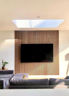 a large flat screen tv mounted to the side of a wall in a living room