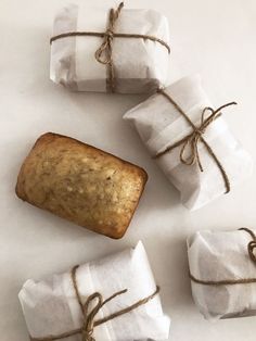 three rolls wrapped in white paper and tied with twine