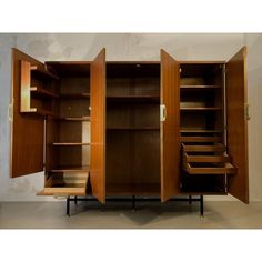 an open wooden cabinet with shelves and drawers