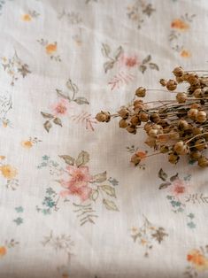 dried flowers are sitting on a floral fabric