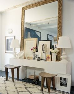 a white table topped with pictures and a large mirror