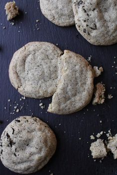 three cookies that are sitting on top of a black surface with crumbs all over them