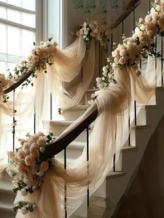 the stairs are decorated with flowers and sheer drapes for an elegant touch to the space