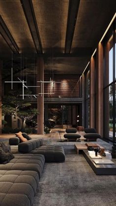 a large living room with couches and tables in front of glass walls that look out onto the outdoors