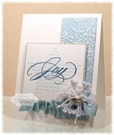 a close up of a greeting card with blue and white ribbon on it, featuring an embellished snowflake