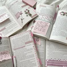 an open book with pink pages and some writing on the pages is surrounded by small pieces of paper that have been pinned to them