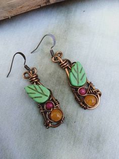 Cute bohemian leaf Earrings, petite on. Natural Tropez gemstone yellow, with Fuschia pink bead, green ceramic leave wire wrapped in bronze wire makes these earrings very unique on. The earrings are half an inch wide, length from bronze hook to bottom earring dangles 2 inches drop. The earrings come gift wrapped in a nice box with a card if you would like a message put on the card please let me no on checkout. Bohemian Leaf-shaped Brass Jewelry, Bohemian Brass Leaf Jewelry, Bohemian Green Earrings With Copper Wire, Green Bohemian Earrings With Copper Wire, Green Bohemian Copper Wire Earrings, Green Copper Wire Earrings Gift, Handmade Bronze Leaf Jewelry, Bohemian Hand-wrapped Copper Wire Earrings, Bohemian Hand Wrapped Copper Wire Earrings