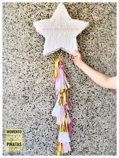 a star hanging on the wall with confetti and streamers attached to it