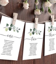 wedding seating cards with flowers hanging from clothes pins