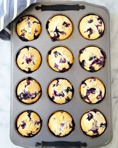 blueberry muffins in a pan on a marble counter