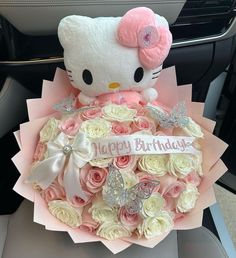 a hello kitty bouquet in the back seat of a car with a happy birthday sign on it