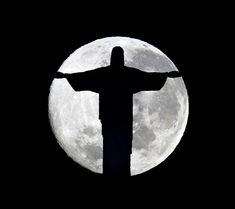 the statue of christ stands in front of a full moon