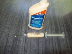 a bottle of liquid next to a syringe on a wooden table with the words 4 use a syntic to fix warped wood veneer