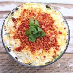 a glass bowl filled with food on top of a wooden table