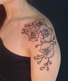 a woman with a tattoo on her shoulder has flowers and leaves in the middle of her arm