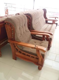 a row of wooden chairs sitting on top of a tiled floor next to each other