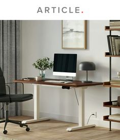 a desk with a computer on it in front of a bookcase and bookshelf