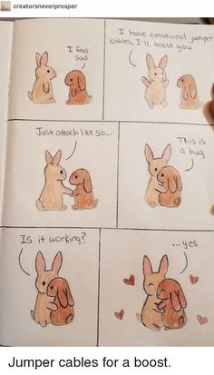 a hand holding an open book with drawings of rabbits on it and the words i love you written in different languages