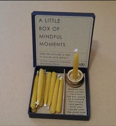 a little box of mindful moments with candles in it and some wax on the inside